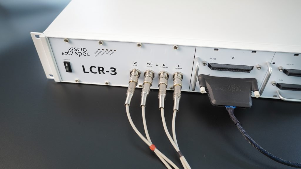 Modular Sciospec LCR-3 instrument with various extension modules and connectors for customizable testing setups.