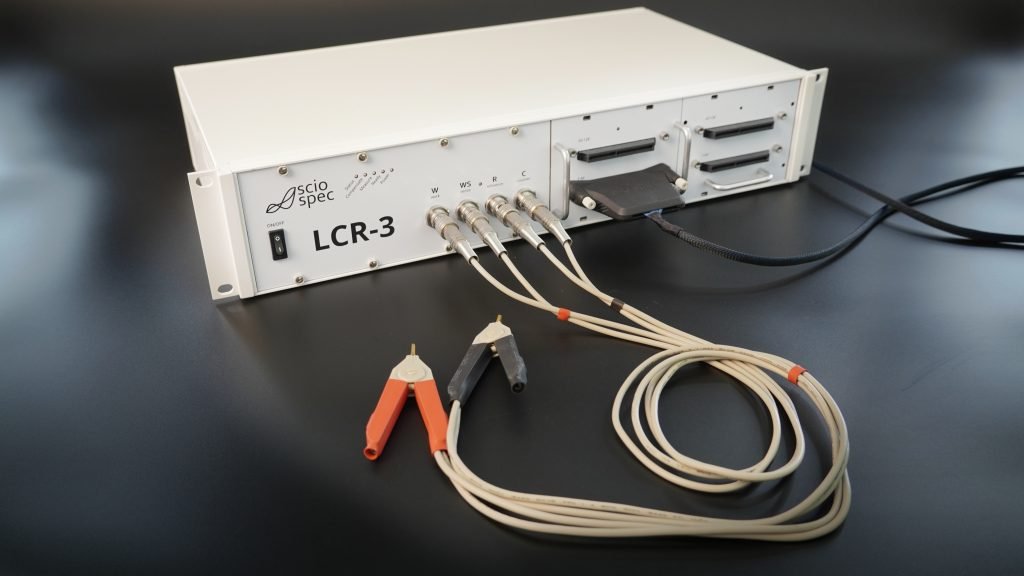 Sciospec LCR-3 with integrated multiplexer, various connectors, adapters, and optional OEM branding.