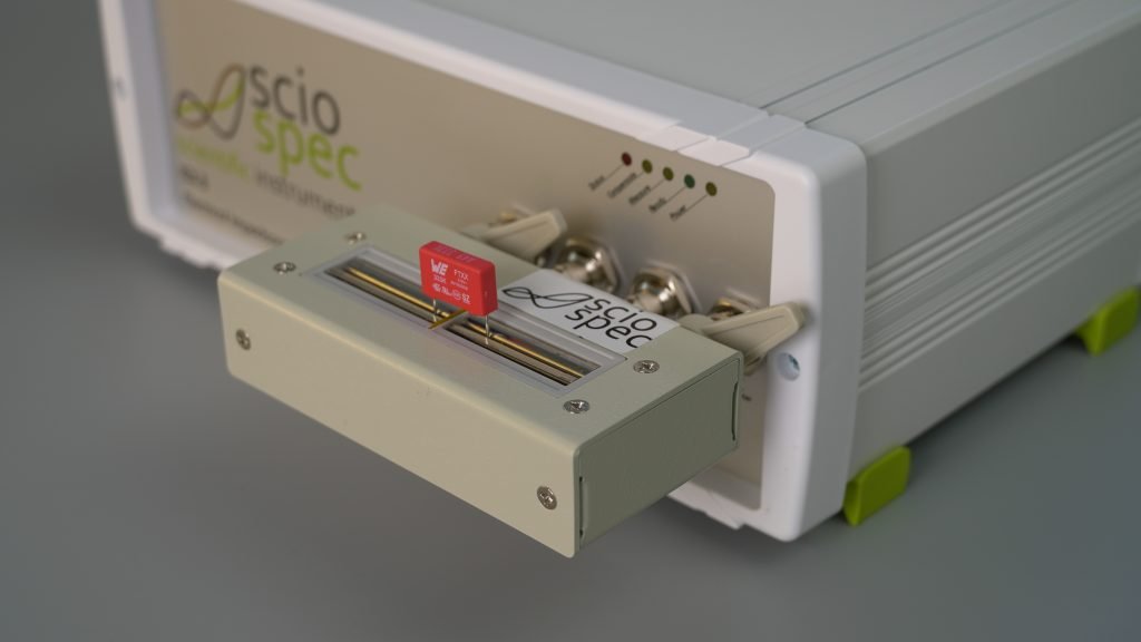 ISX-3 impedance analyzer in a component testing setup with various electronic components.